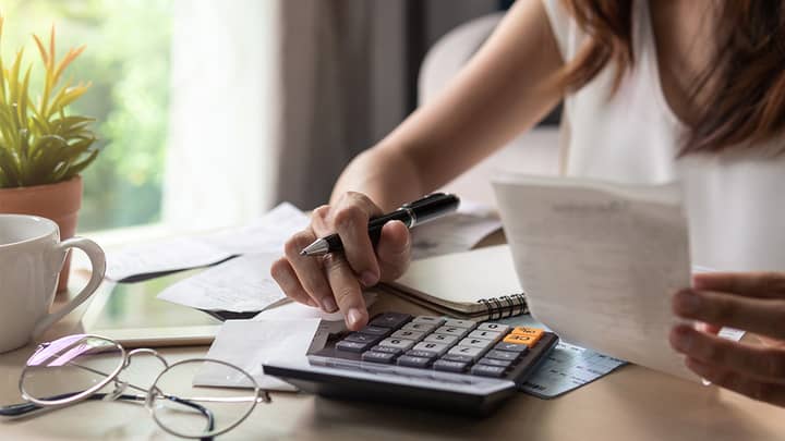 woman using calculator and looking at a receipt