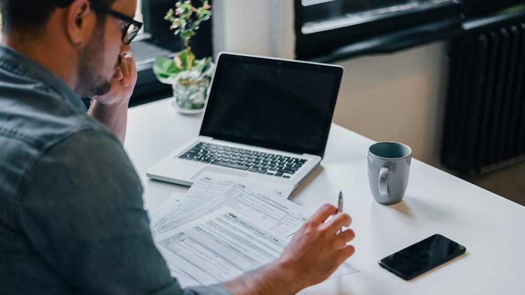 businessman sitting at desk working on paperwork and calculations