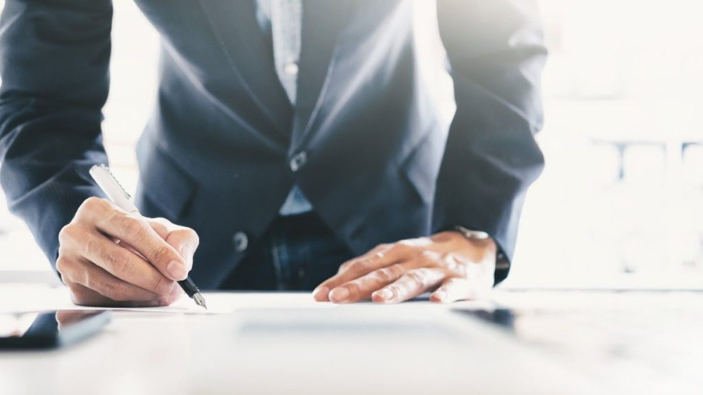 businessman filling out form on a desk