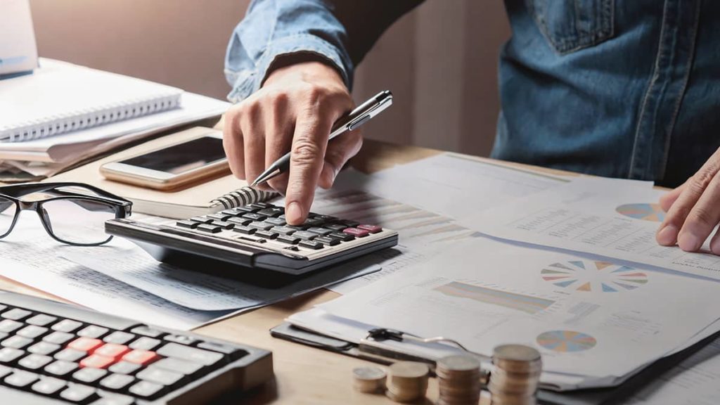 businessman calculating taxes at his desk