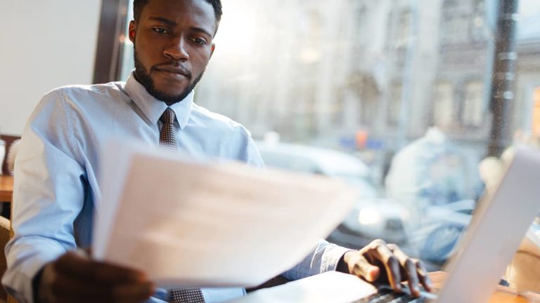 man looking at paper learning how to apply for EIN