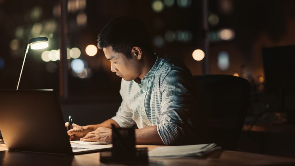 man working late at night with lamp light